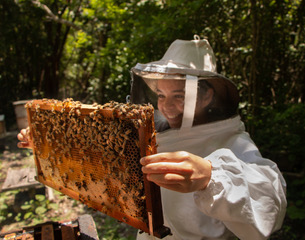 mujer apicultor sosteniendo panal